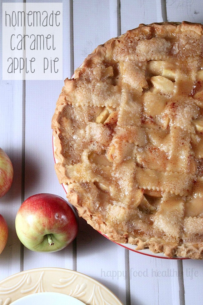 Caramel Apple Pie on a cutting board with fresh apples.
