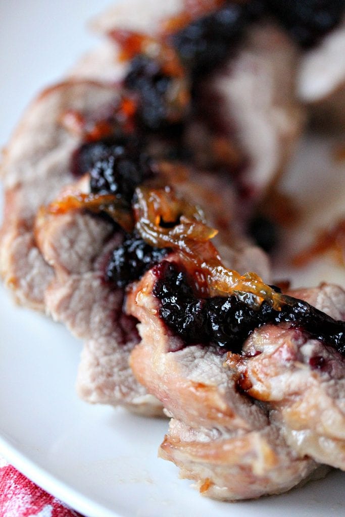 Pork Tenderloin with Haskapa Chutney served on a white plate with a red and white napkin underneath