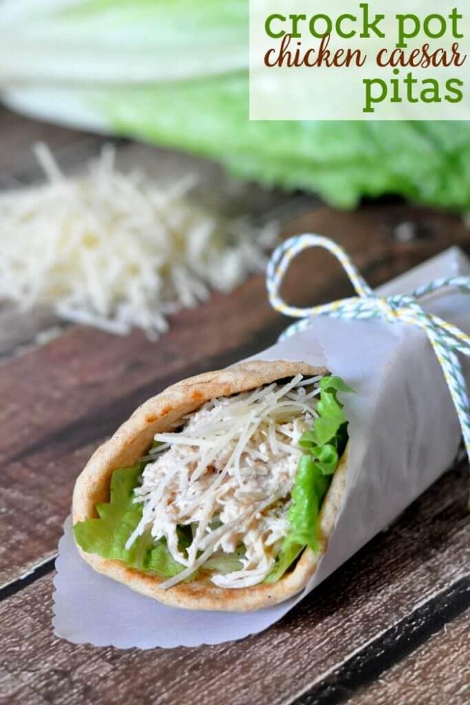 Crock Pot Chicken Caesar Pita wrapped in paper on a cutting board.