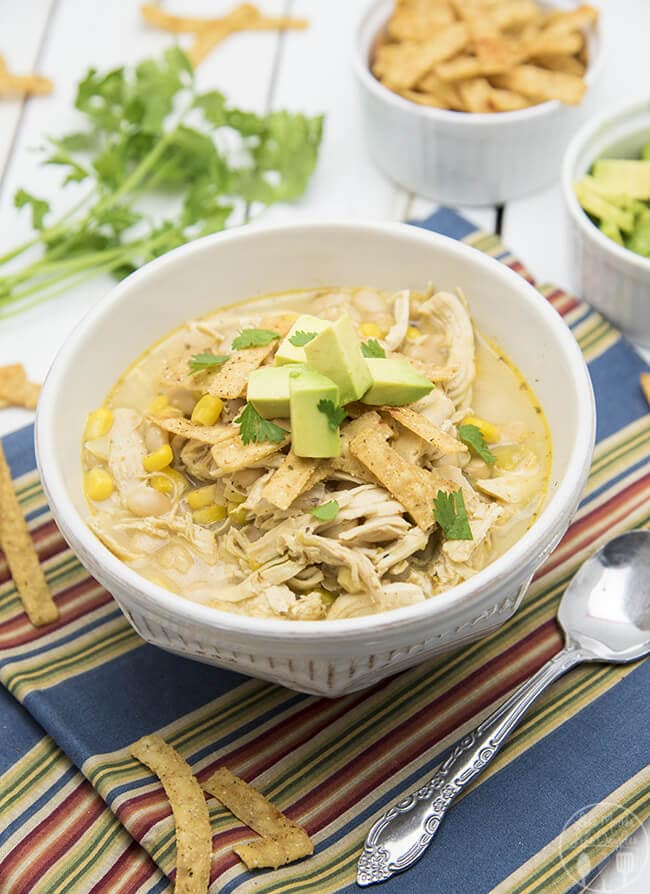 Slow Cooker White Chicken Chili in a white bowl with a spoon.
