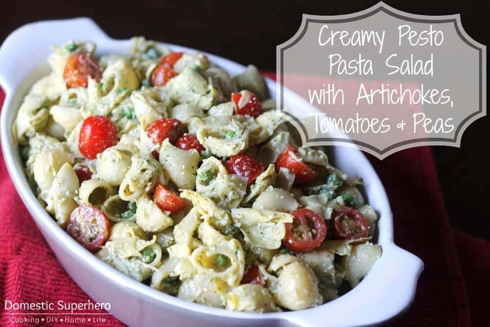 Creamy Pesto Pasta Salad with Artichokes, Tomatoes, and Peas in a white bowl on memorial day.