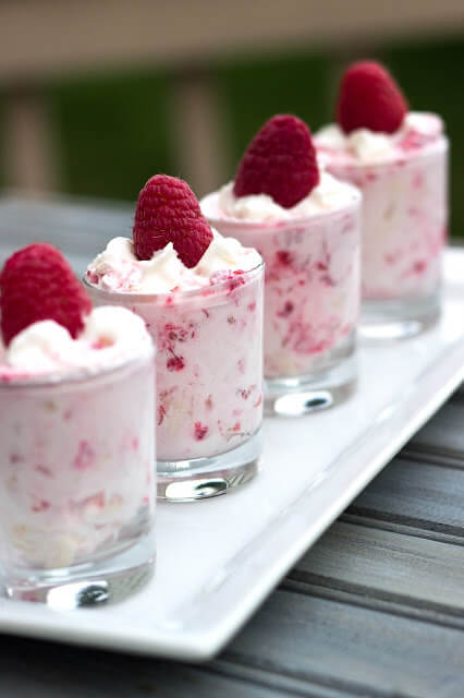 Raspberry Shooters in glasses on a white plate.