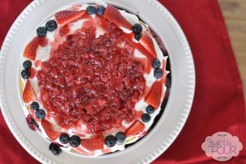 Red, White, and Blueberry Cheesecake on a white plate.