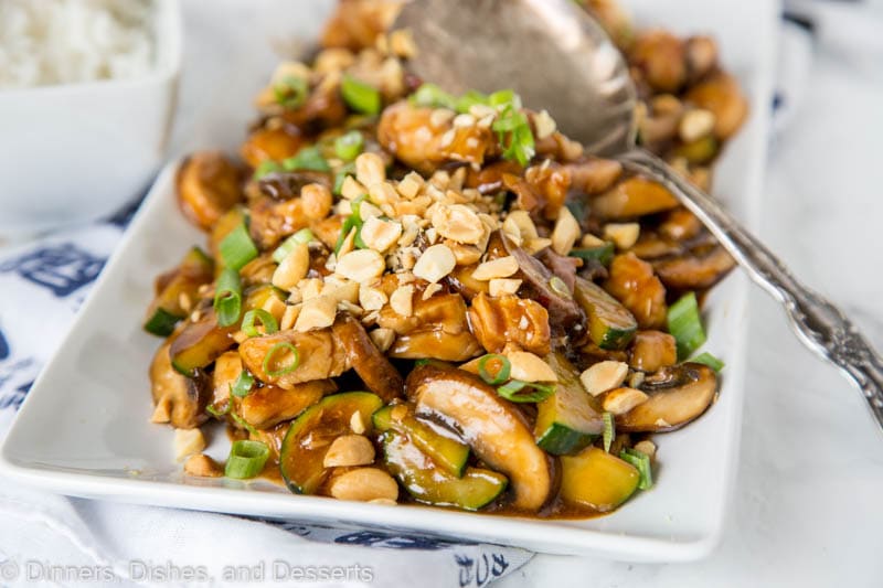 a plate of kung pao chicken and a serving spoon