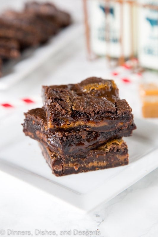 chocolate caramel brownies stacked on a plate