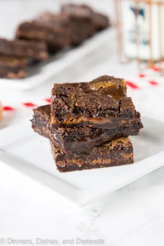 chocolate caramel brownies stacked on a plate