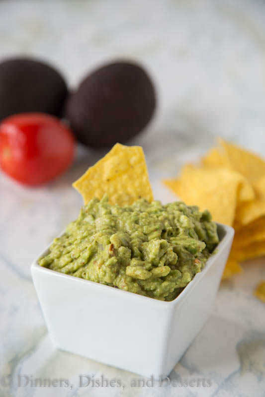 Homemade Guacamole - super easy dip recipe with ripe avocados, tomatoes, onions and a couple spices. Perfect with tortilla chips.
