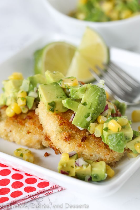 Shrimp cakes topped with avocado corn salsa sitting on a plate