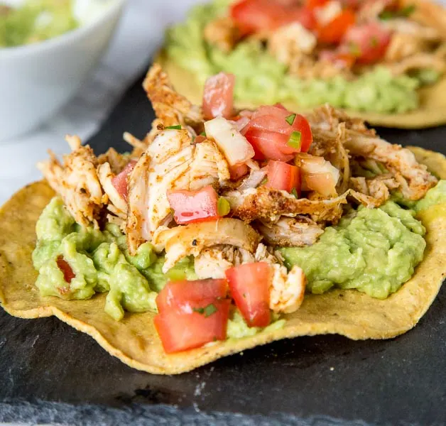 chicken tostada with guacamole on a plate