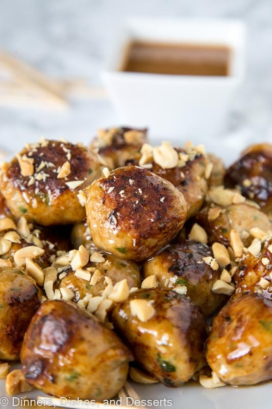 a plate of chicken meatballs with chopped peanuts