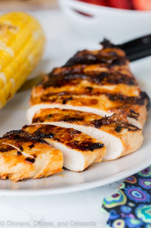 sliced chicken on a plate with an ear of corn