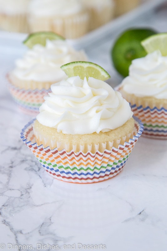 close up of margarita cupcakes topped with frosting and a lime slice