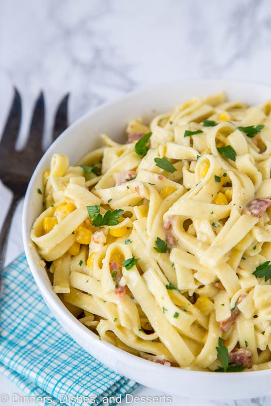 pasta carbonara with corn and chilies in a bowl with a serving fork