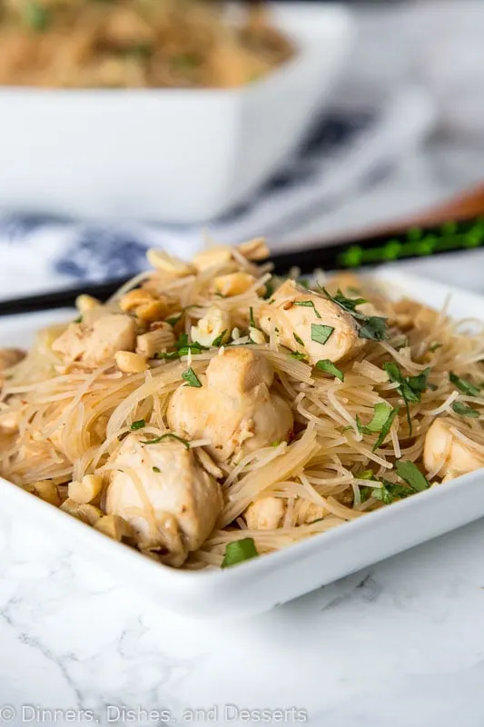 asian noodles with chicken on a plate with chopsticks
