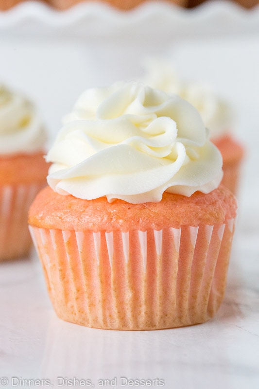close up of strawberry almond cupcakes topped with frosting