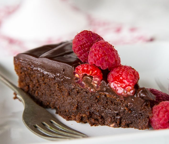 Flourless Nutella Cake - A rich and fudgy flourless chocolate cake full of Nutella! Top with raspberries for hazelnuts for a decadent dessert.