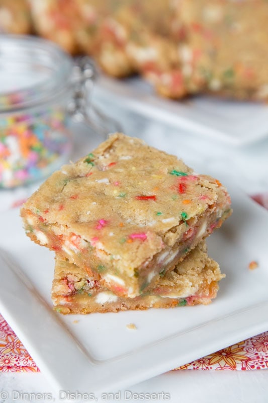 coconut blondies with white chocolate chips and sprinkles stacked on a plate