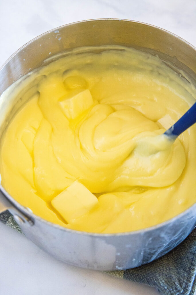 A spatula stirring butter into pudding