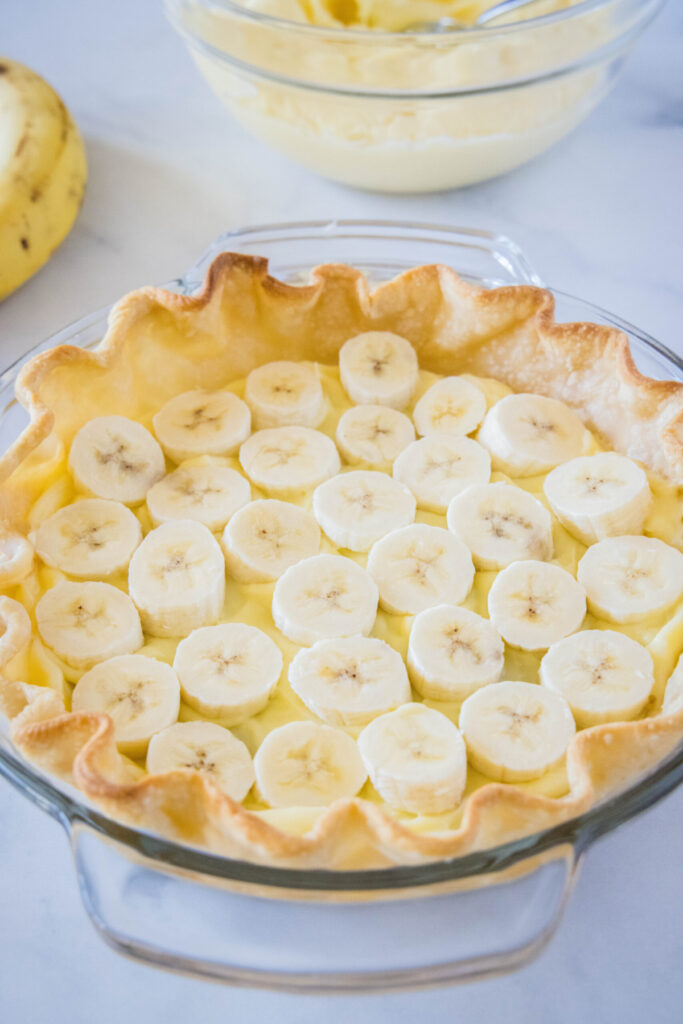 A layer of sliced bananas at the base of a pastry shell