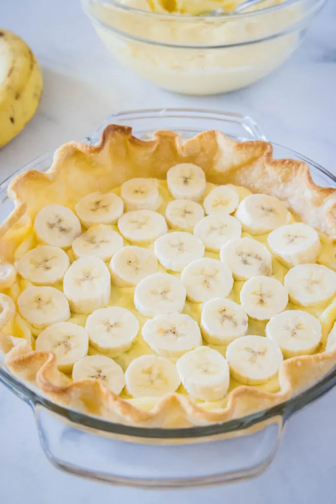 A layer of sliced bananas at the base of a pastry shell