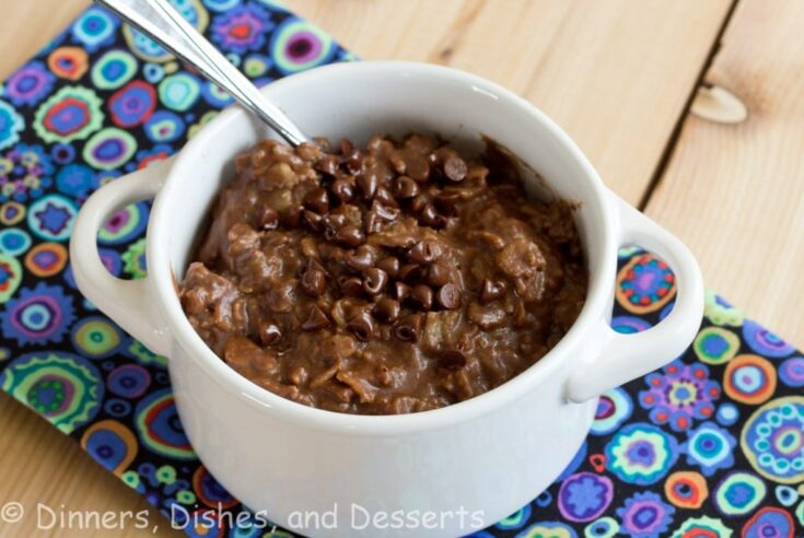 Chocolate Peanut Butter Oatmeal in white bowl with spoon on wood board