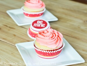 vanilla cupcake with pink frosting on white plate