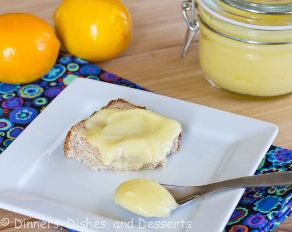 lemon curd on bread on white plate with lemons on background