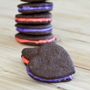 heart shaped chocolate sandwich cookies with pink and purple frosting