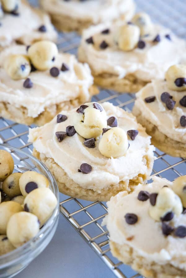 Frosted cookie dough cookies on a wire rack.