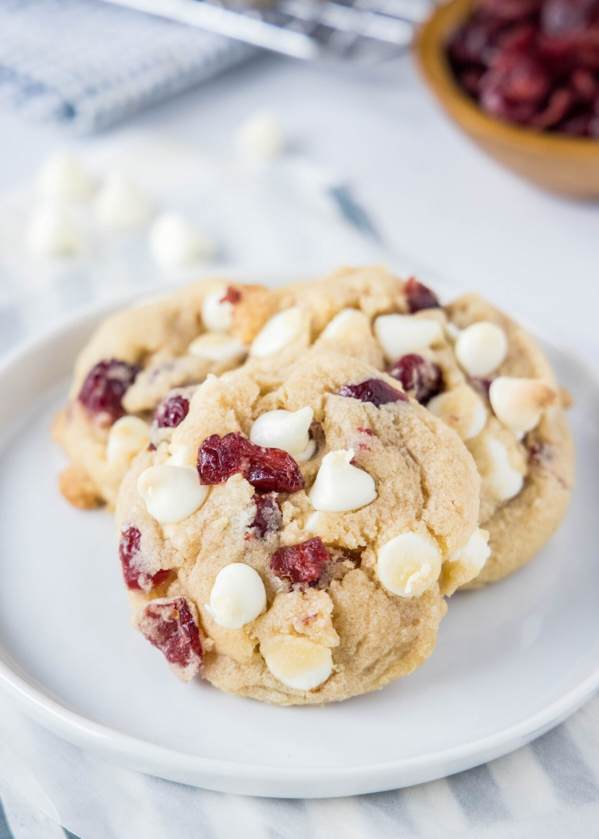 Close up of three white chocolate cranberry cookies on a plate
