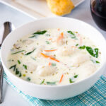A bowl of soup on a table, with Olive Garden