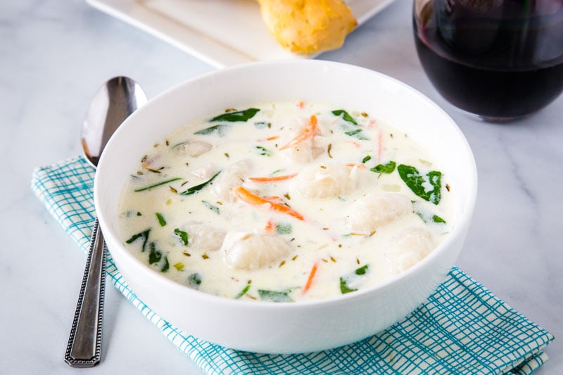 A bowl of soup on a table, with Olive Garden