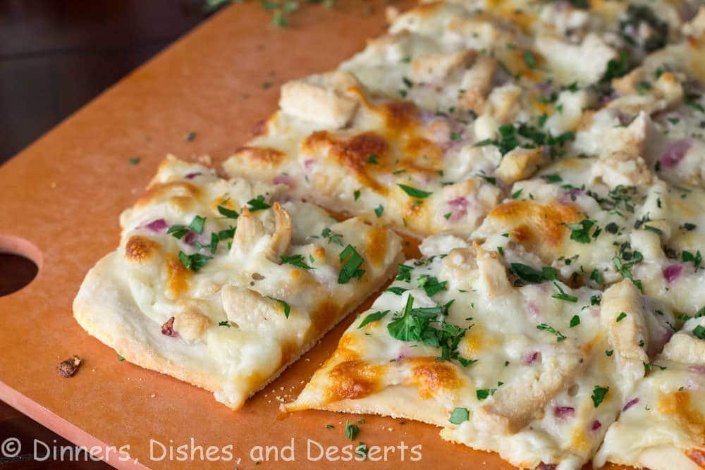 roasted garlic chicken and herb white pizza on a board