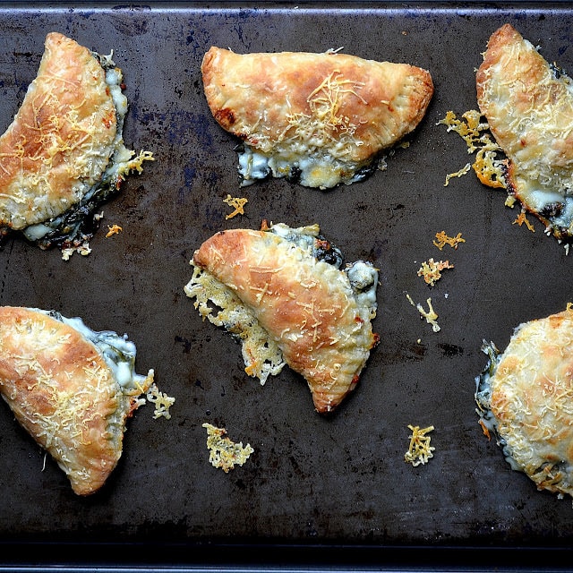 spinach artichoke hand pies on a pan