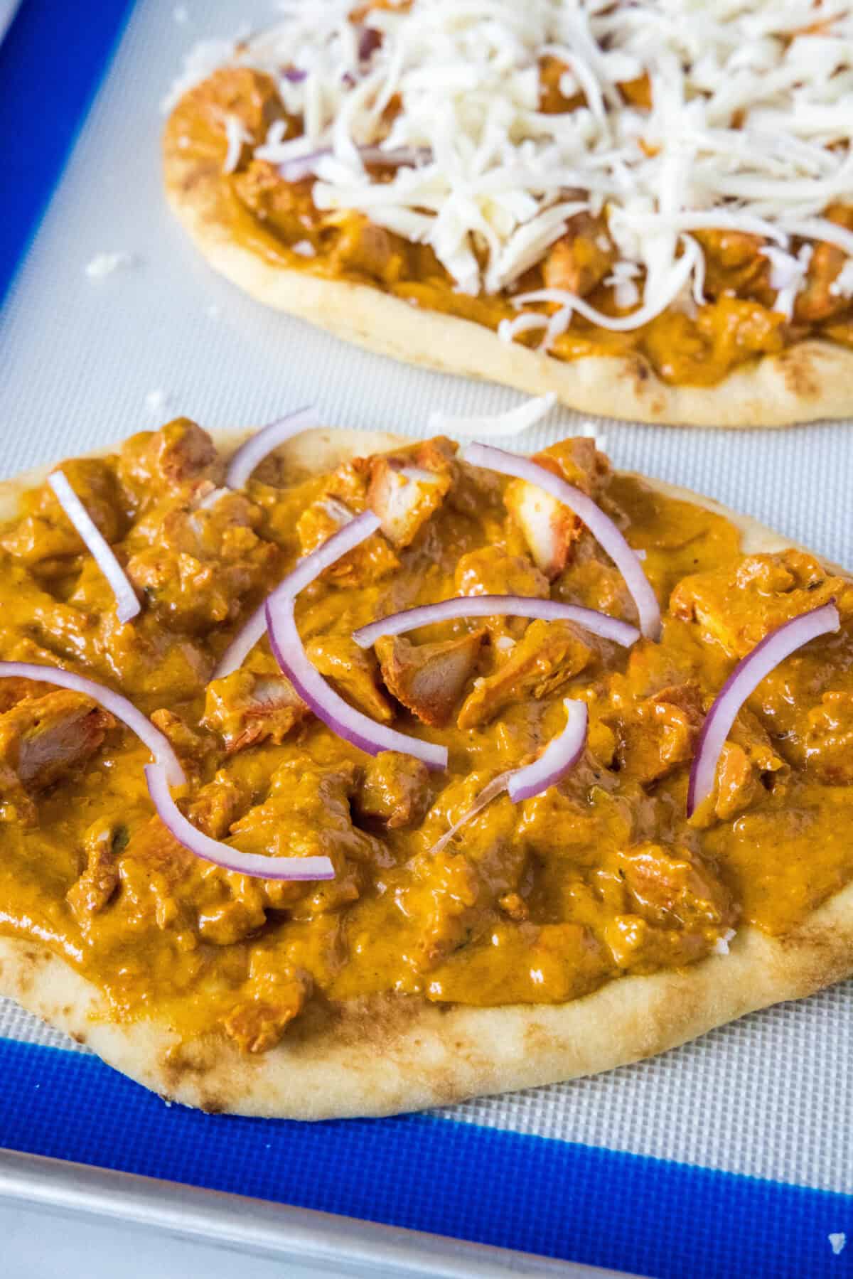 adding chicken and red onion to naan bread