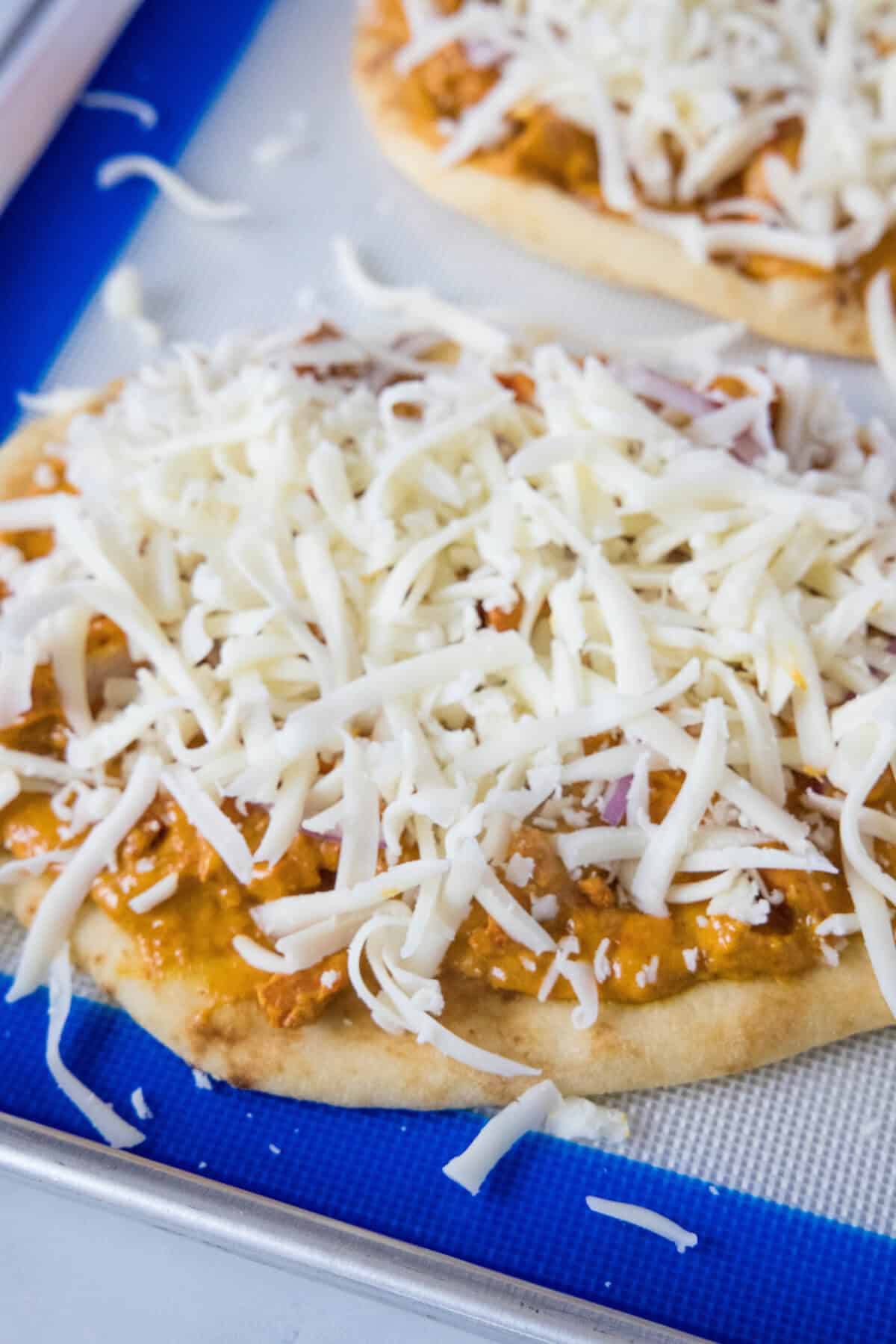 adding cheese to pizza