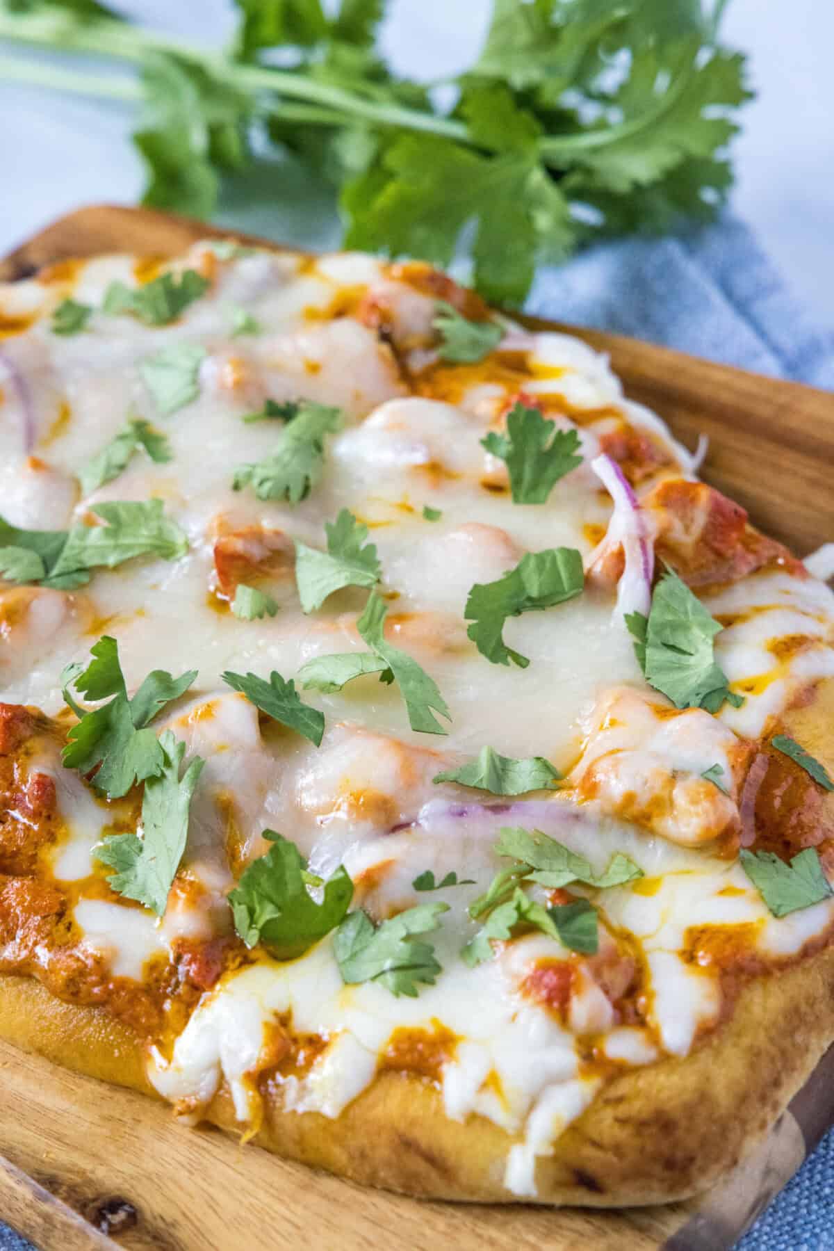 Chicken Tikka Pizza | Dinners, Dishes, and Desserts chicken tikka pizza topped with cilantro on cutting board