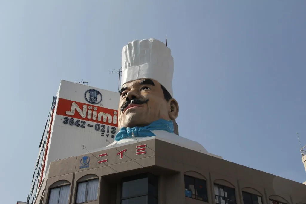 A large tower that has a chef on the side of a building