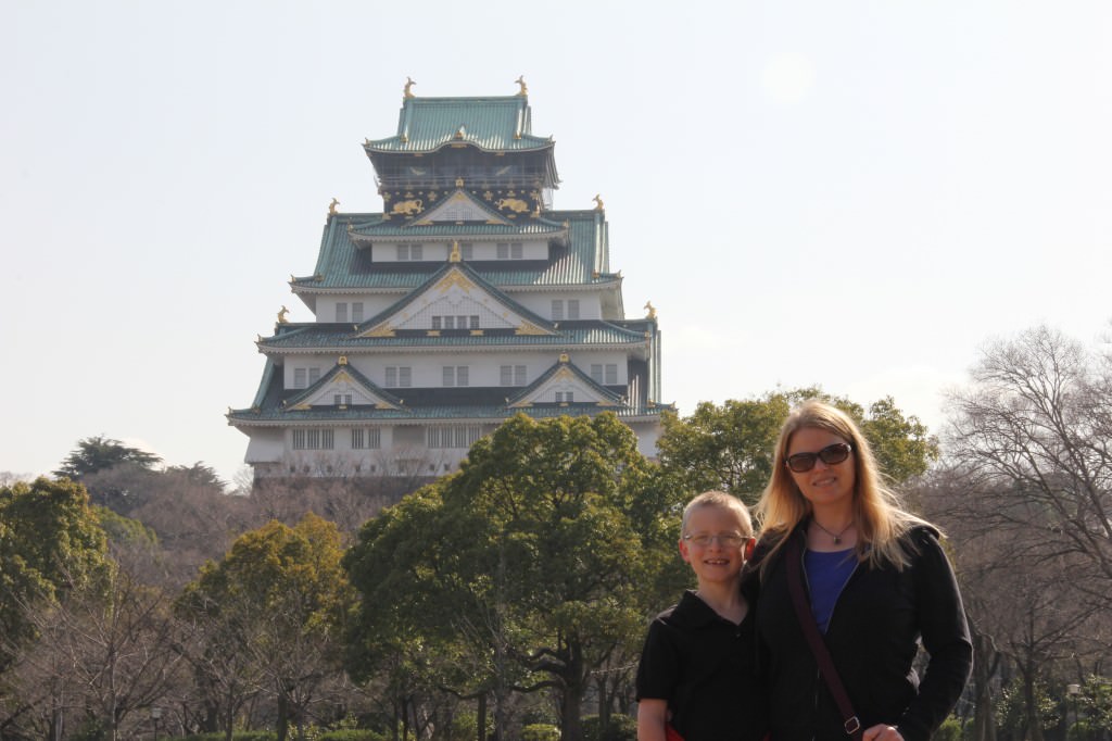 A person standing in front of Osaka Castle
