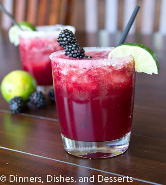 A glass cup on a table, with Margarita 