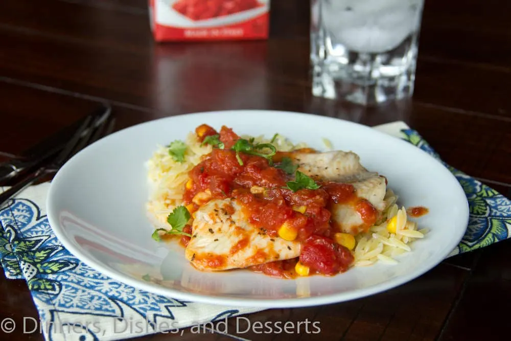 tilapia with tomatoes and orzo on a plate