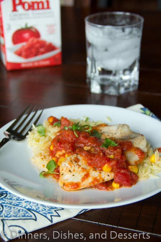 tilapia with tomatoes and orzo on a plate