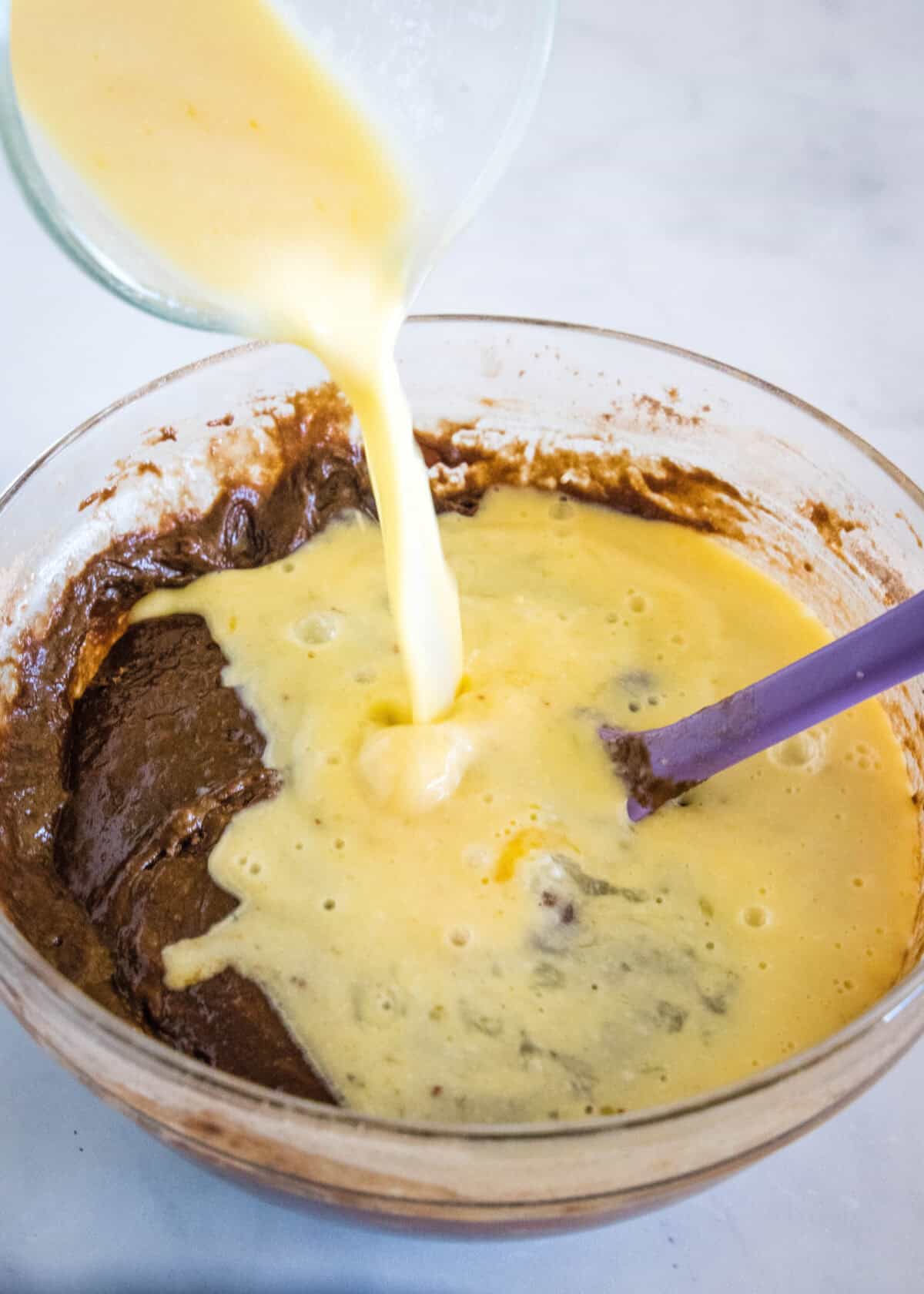 adding egg mixture to chocolate cake batter