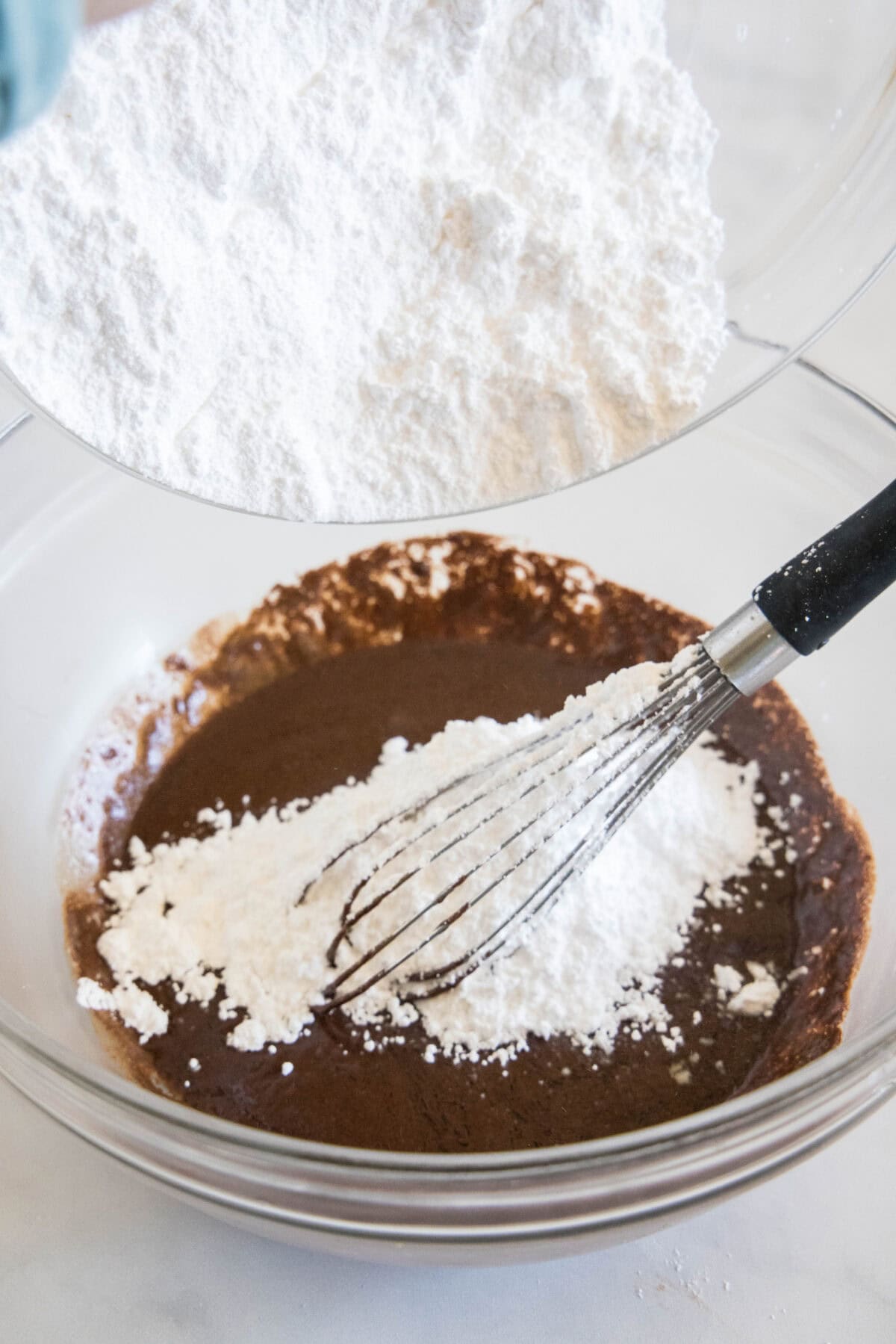 adding powdered sugar to chocolate mixture for frosting