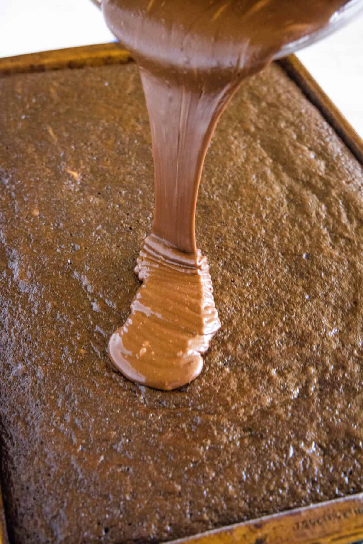 pouring frosting on sheet cake