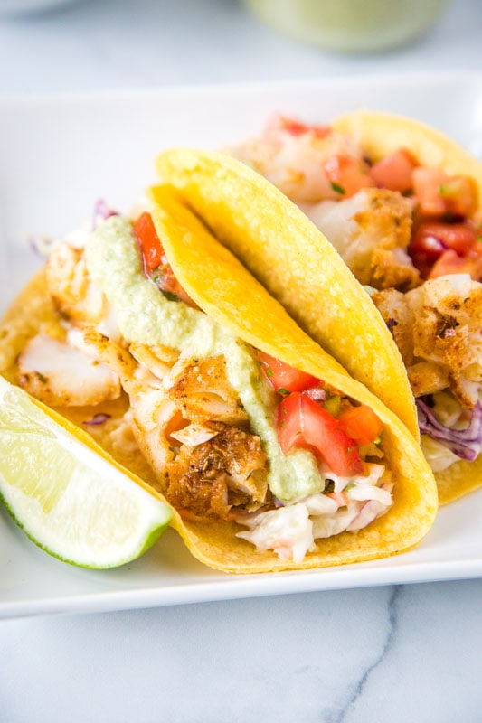 fish tacos in corn tortillas and lime wedge