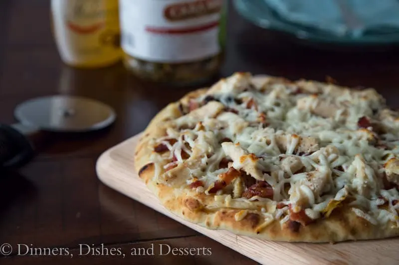 grilled artichoke chicken and bacon pizza on a board