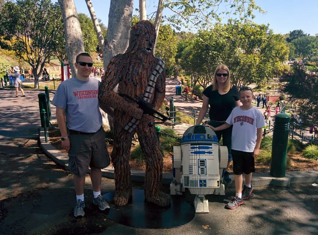 people standing by chewbacca and r2d2 lego figures