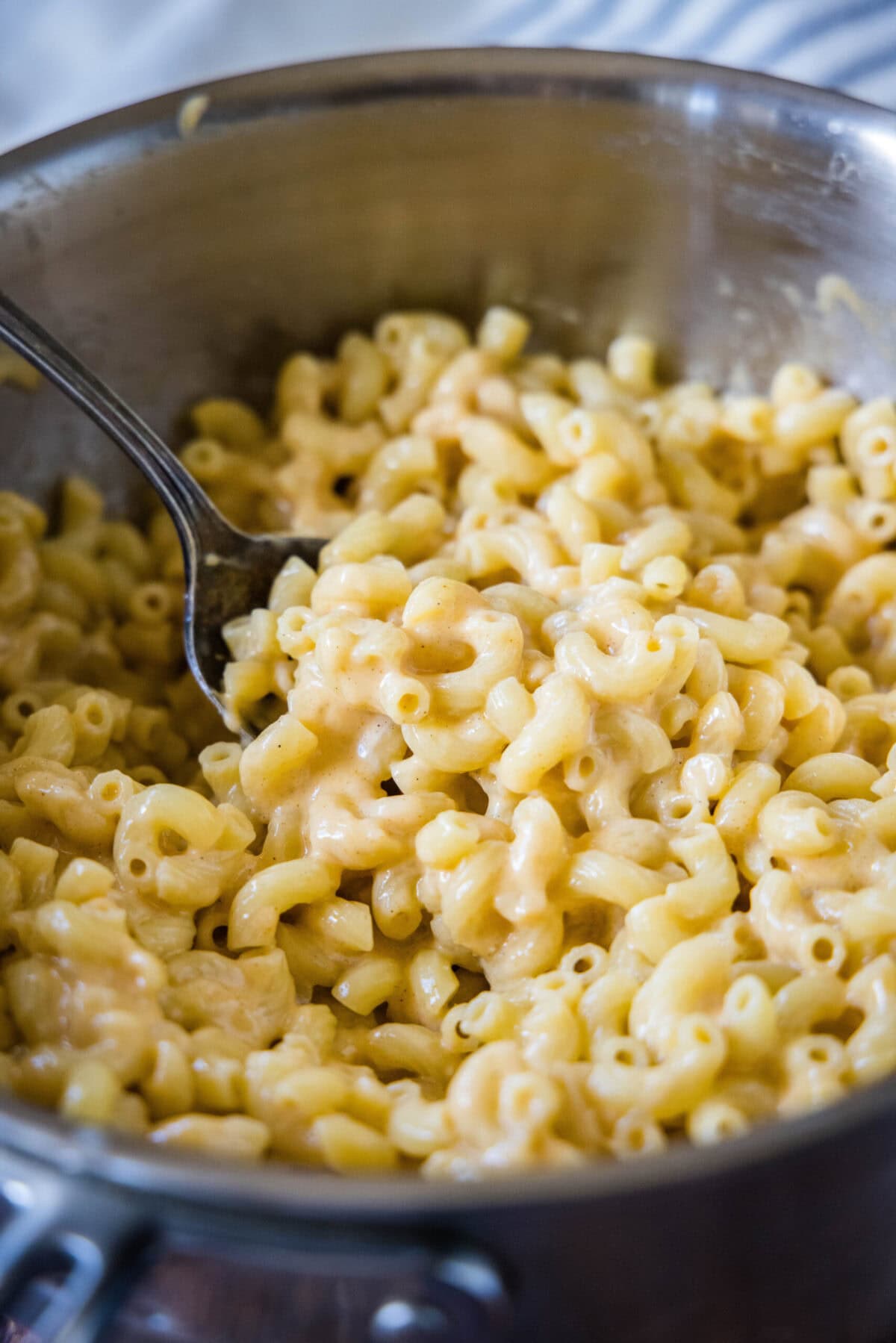 A pot full of mac and cheese with a serving spoon in it