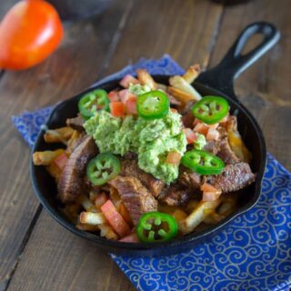 Carne Asada Fries - french fries topped with Carne Asada, melted cheese, and guacamole!
